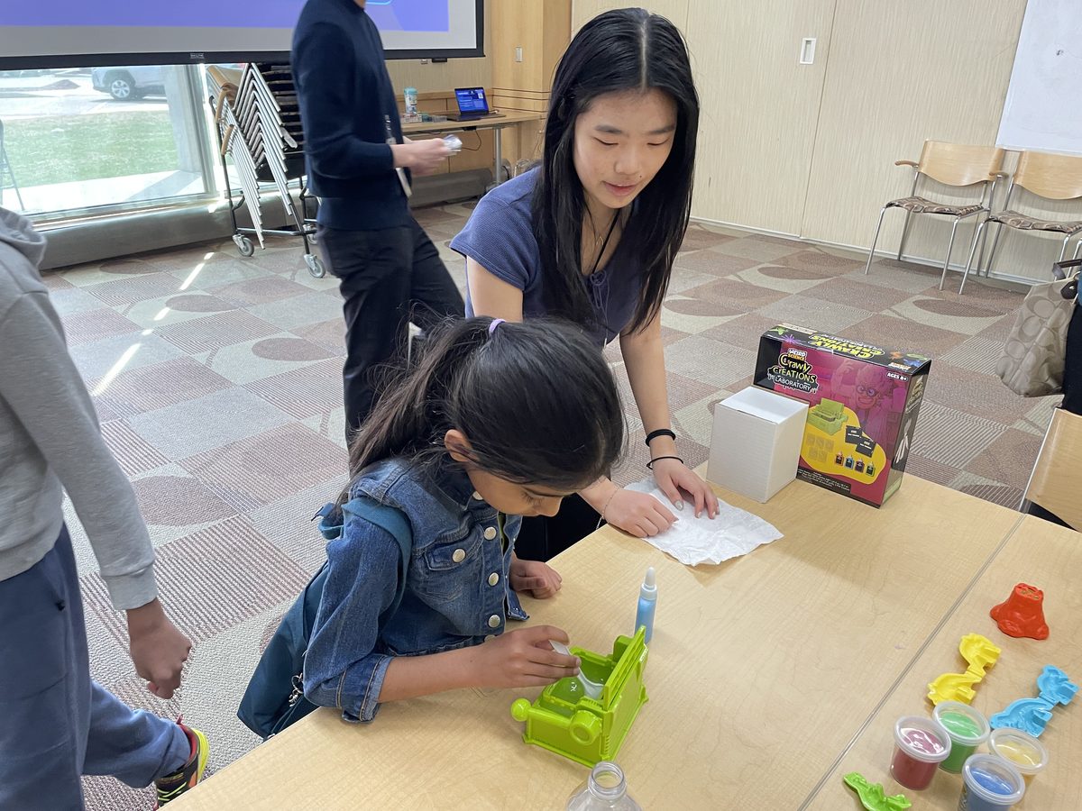 Volunteer helping a child with a lab kit